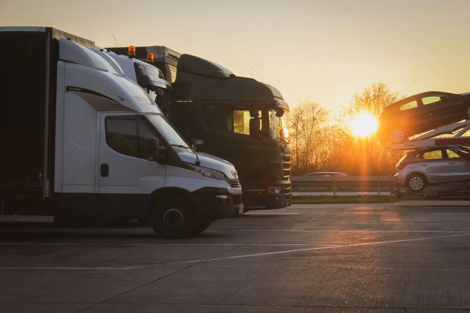 Semi trucks staged at a freight yard at golden hour